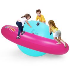 three children are playing on an inflatable object with two girls and one boy