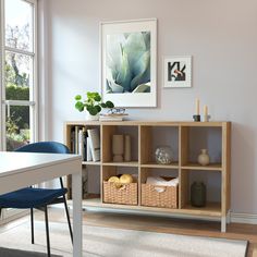 a room with a table, chairs and pictures on the wall in front of it