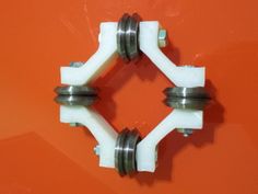 two white handles on an orange surface with metal fittings and nuts in the middle