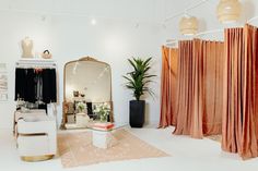 a room with curtains, a chair and a mirror in the center is decorated with pink drapes