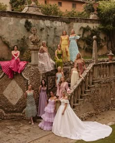 a group of women standing next to each other on top of a stone staircase in front of a building