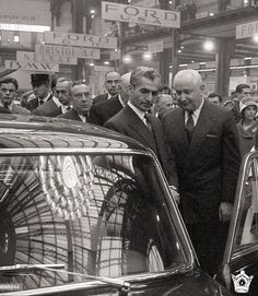 men in suits and ties standing next to a car