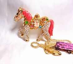 Theme:            Circus Horse Dressage  Type Jewelry: Necklace only (NOT convertible) Size:                 2.75" W X 2" H Chain:              23" - 25" This gorgeous necklace by Betsey Johnson has a dressy horse with a tail that swishes! The tail moves back & forth. It is New Old Stock and has the original tag. It is in perfect condition. I recently acquired a great deal of NOS Betsey Johnson jewelry, mostly necklace/pin convertible items. It has the original paper tag. Check out my other list Circus Horse, Colorful Crystals, Show Horse, Horse Dressage, Horse Pony, Pink Enamel, Paper Tags, Gorgeous Necklaces