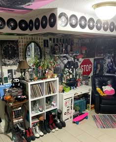 a room filled with lots of clutter next to a black chair and white book shelf