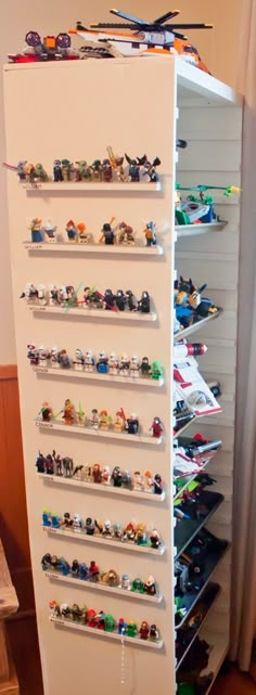 a tall white shelf filled with lots of legos