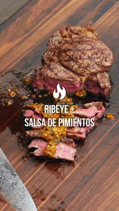 a steak on a cutting board with the words ribeye and salsa de pimentoos