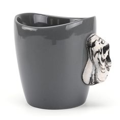 a gray cup with a dog's head sticking out of it