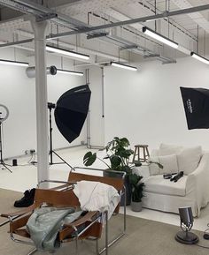 an empty room with white couches and black umbrellas