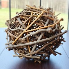 a ball made out of twigs sitting on top of a table