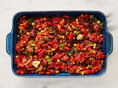 a casserole dish filled with black beans, corn and peppers on a marble countertop