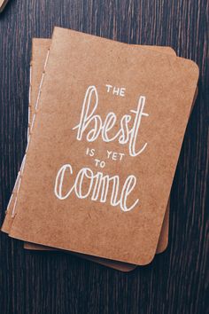 the best is yet to come written on top of a brown notebook next to a cup of coffee