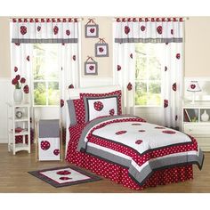 red and white bedding with ladybugs on the bedspread in a child's bedroom