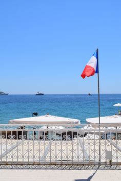 the flag is flying in front of an ocean view