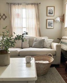 a living room filled with furniture and a white coffee table in front of a window