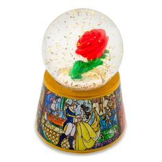 a snow globe with a red rose in it