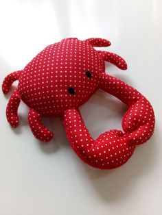 a red crab stuffed animal with white polka dots