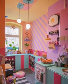 a colorful kitchen with pink, blue and green walls