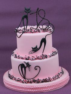 a three tiered cake with black cats on top