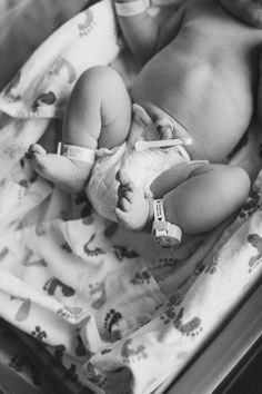 a baby laying in a crib with its head on the arm of someone's hand