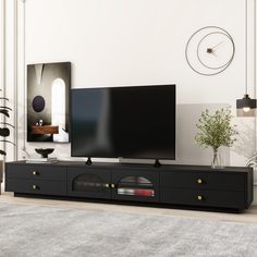 a flat screen tv sitting on top of a black entertainment center in a living room