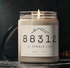 a candle is sitting on a table with a house number sticker in front of it