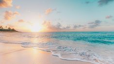 the sun is setting over an ocean with white sand and blue water in front of it