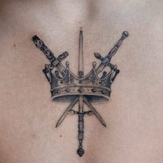 a tattoo with two swords and a crown on it