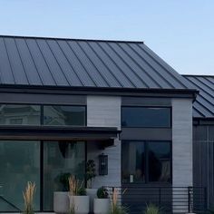 a modern house with metal roofing and glass doors on the front door is shown