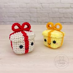 two small crocheted boxes with bows on them, one is yellow and the other is red