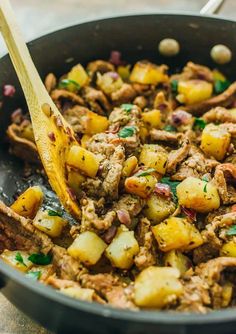 a skillet filled with meat and potatoes