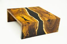 a wooden table with black and yellow designs on it's sides, sitting against a white background