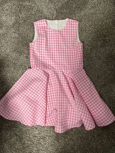 Beautiful  Barbie inspired pink gingham checked twirl dress..  The gingham fabric is Robert Kaufman  cotton.  The sleeveless dress has a fully lined bodice.  The back closes with kam Plastic  snaps.  The dress has a full circle twirl for that little dancer.    I would be happy to make this dress in other colors or fabric.  available in sizes 12 months to size 8  Measurements will be in the photo section Spring Gingham A-line Dress, Playful Gingham Dress For Spring, Playful Gingham Dress With Ruffles, Playful Sleeveless Gingham Dress, Spring Playful Gingham Dress, Spring Plaid A-line Dresses, Cute Sleeveless Plaid Dress, Cute Plaid Sleeveless Dress, Pink Spring Dress For Picnic