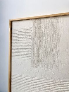 a white wall with lines drawn on it and a wooden frame in the middle that is holding a piece of artwork