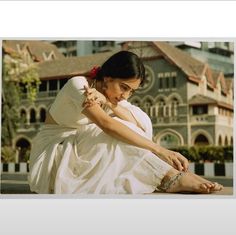 a woman in white dress sitting on the ground