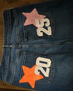 two patches on the back of a pair of jeans with numbers and stars painted on them