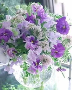 a glass vase filled with purple and white flowers