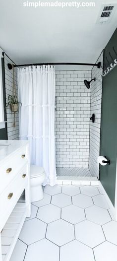 a bathroom with white tile and green walls