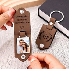 a person holding a keychain that has a photo on it and the words drive safe, i need you here with me