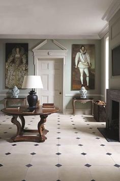 a living room filled with furniture and paintings on the wall above it's doorway