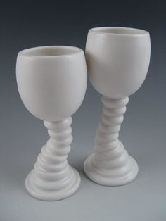 two white goblets sitting next to each other