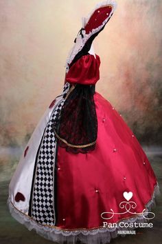 a red dress with black and white checkerboard on the skirt is displayed in front of a painting