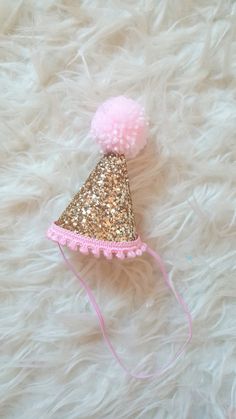 "READY TO SHIP as shown Non shedding glitter Mini Party Hat Pale gold hat Baby pink trim and pom Shown as is without a number If you would like a number please message for a custom order Mini party hat measures 3\" tall x 2.5\" in diameter" Pink Cake Smash, First Birthday Hats, 1st Birthday Photoshoot, Gold Hats, Beautiful Nursery, Cake Smash Photos, Mini Party, Gold And Pink, Birthday Hat