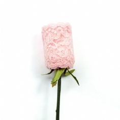 a single pink rose with green stems on a white background in the shape of a crochet flower