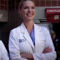 two women in white lab coats standing next to each other with their arms crossed and looking at the camera