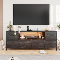 a flat screen tv mounted to the side of a wooden dresser in a living room