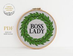 a cross - stitch pattern with the words boss lady in black and green leaves on it