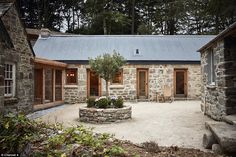 an old stone building with a tree in the courtyard