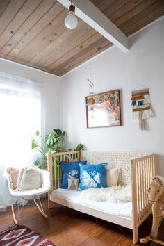 a baby's room with a crib, rocking chair and window