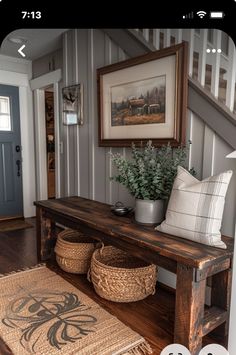 a wooden bench sitting next to a stair case with baskets on the bottom and a rug underneath it