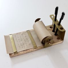 a piece of paper and some scissors on top of a wooden block with writing on it